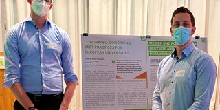 JProf Dr. Simon Hensellek and Jonah Weißwange in front of the Cowork4EU poster at the Global Gallery 2022